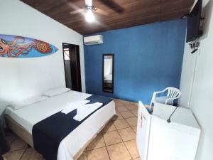um quarto com 2 camas e uma parede azul em Pousada Boiçucanga a 30m da praia em Boicucanga