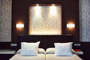 a bedroom with a bed with two pillows at Hotel Alda Carril in Vilagarcia de Arousa