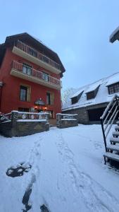 un edificio con la neve sul terreno di fronte ad esso di Hotel Saueth a Tredós