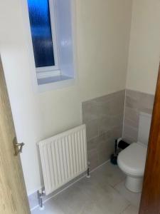 a bathroom with a toilet and a window at Beautiful 3-Bed Bungalow in Bawtry Doncaster in Doncaster