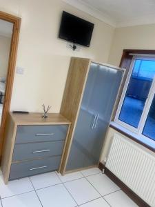 a kitchen with a refrigerator and a tv on the wall at Beautiful 3-Bed Bungalow in Bawtry Doncaster in Doncaster