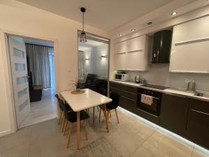 a kitchen with a table and chairs in a room at Boznicza Modern Apartment, self check-in 24h, free parking in Poznań