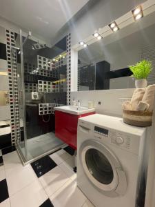 a bathroom with a washing machine and a sink at Boznicza Modern Apartment, self check-in 24h, free parking in Poznań