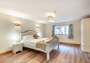 a bedroom with a white bed with a teddy bear on it at The Priory in Upwell