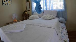 a bedroom with a large white bed with a blue headboard at welcome to putuo ecolodge hidden germ of Solomon 