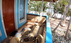 a porch with two wicker chairs and a window at welcome to putuo ecolodge hidden germ of Solomon in Dadale