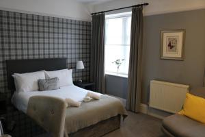 a bedroom with a bed with a chair and a window at Norfolk Arms in Glossop