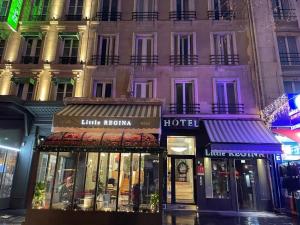 ein Geschäft vor einem Gebäude in der Nacht in der Unterkunft Hotel Little Regina in Paris