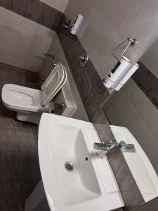 een badkamer met een witte wastafel en een toilet bij hostel Wyra home stay Jaisalmer in Jaisalmer