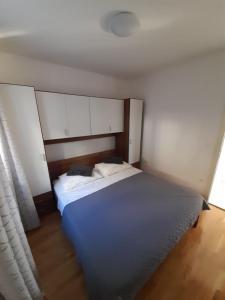 Schlafzimmer mit einem großen Bett und weißen Schränken in der Unterkunft Pere Apartment in Omiš