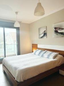 um quarto com uma cama grande e uma janela grande em Apartamento Plaza Arena em Sanxenxo