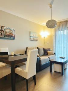 uma sala de estar com uma mesa e um sofá em Apartamento Plaza Arena em Sanxenxo