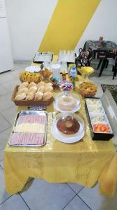 une table remplie de nourriture sur une table jaune dans l'établissement Hospedaria Ipiranga, à São Paulo
