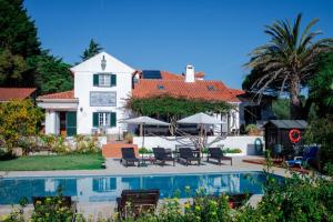 a house with a swimming pool in front of a house at Quinta Verde Sintra - Casa de Campo in Sintra