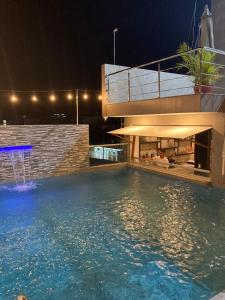 a swimming pool in front of a house at night at Hotel Europa in Iquitos