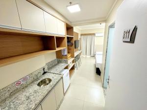 eine Küche mit einem Waschbecken und einen Flur mit einem Zimmer in der Unterkunft Spazzio Diroma - com acesso Acqua Park in Caldas Novas