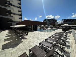 a group of chairs and umbrellas next to a building at Spazzio Diroma - com acesso Acqua Park in Caldas Novas