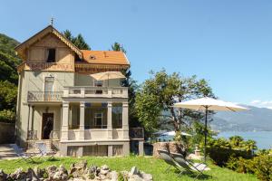 a house with an umbrella in front of it at Ca Meison in Cannobio