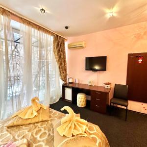 a bedroom with a bed and a desk and a tv at Kizhi ART Hotel Kharkiv in Kharkiv