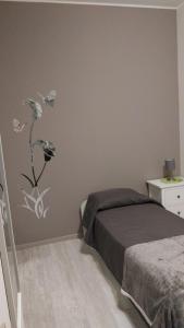 1 dormitorio con 1 cama con un adorno floral en la pared en Family en Potenza