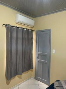 a room with a curtain and a heater and a door at Ap completo ótimo local próximo shopping 1 in Campo Grande