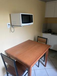 a kitchen with a table and a microwave on the wall at Ap completo ótimo local próximo shopping 1 in Campo Grande