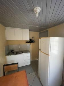 a kitchen with a white refrigerator and a table at Ap completo ótimo local próximo shopping 1 in Campo Grande