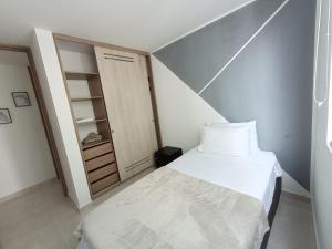 a small bedroom with a bed and a closet at Apartamentos en Club Residencial con Piscina in Ibagué