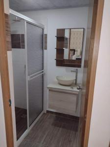 La salle de bains est pourvue d'un lavabo et d'une douche en verre. dans l'établissement Casa Hostal M&M, à Norcasia