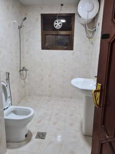 a bathroom with a toilet and a sink at Cozy Corner 2024 in Abu Dhabi