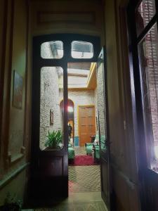 una persona está mirando a través de la puerta de una casa en El Patio de la Morocha, en Montevideo
