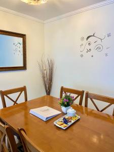 una mesa de comedor con un libro y flores. en Apartamentos Alma Surire en Arica