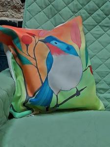Una almohada con un pavo real en una cama en El Patio de la Morocha, en Montevideo