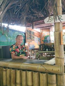 a woman sitting at a counter with a drink at Club Beach Ocean House in Juan de Acosta