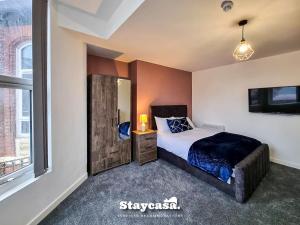 a bedroom with a bed and a tv and a window at Stylish 10 Bedrm House, Fast Wifi, Free Parking in Manchester