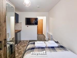 a bedroom with a bed with two towels on it at Stylish 10 Bedrm House, Fast Wifi, Free Parking in Manchester