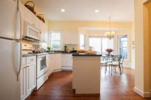 ブラック・マウンテンにあるRed Plum Town Homeの白いキャビネットとテーブルと椅子のあるキッチン +15枚の写真