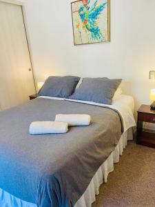 a bedroom with a bed with two towels on it at Apartamentos Alma Surire in Arica
