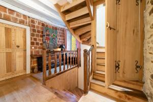 a hallway with wooden stairs and a brick wall at La maison de Ganil in Saint-Cirq-Lapopie