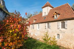 un antiguo edificio de piedra con techo marrón en La maison de Ganil en Saint-Cirq-Lapopie