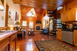 ピジョン・フォージにあるSmoky Mountain Retreat- Resort Cabin with modern amenities in the heart of PFのキッチン、ウッドフロアのリビングルーム