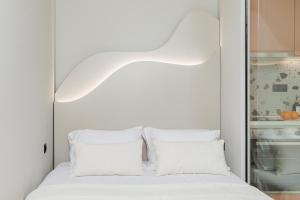 - une chambre blanche avec un lit et des oreillers blancs dans l'établissement Lagon Suite by Alchemia, à Thessalonique