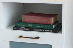 tres libros sentados en la parte superior de un estante en Luxury Ensuite Room - With Full Privacy as only room on the top floor! en Dublín