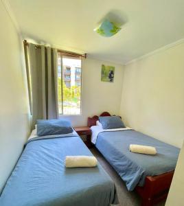 a bedroom with two beds and a window at Apartamentos Alma Surire in Arica