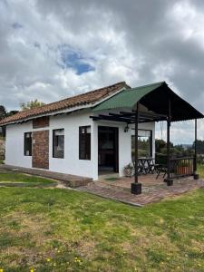 a small white building with a green roof at Zingara de la Montaña: Hermosa Casa en Zipaquira in Zipaquirá