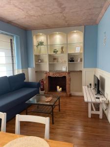 sala de estar con sofá azul y chimenea en Sweet Home Encantadora casa en Valdepeñas, en Valdepeñas