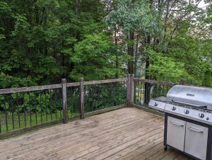 a grill on a wooden deck with a fence at Chalet le Rassembleur in Racine