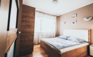 een kleine slaapkamer met een bed en een raam bij Baltic Summer - ośrodek dla rodzin z dziećmi in Rewa