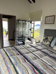 ein Schlafzimmer mit einem großen Bett und ein Zimmer mit Aussicht in der Unterkunft Zingara de la Montaña: Hermosa Casa en Zipaquira in Zipaquirá