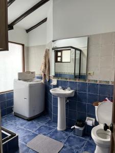 Baño de azulejos azules con aseo y lavamanos en Zingara de la Montaña: Hermosa Casa en Zipaquira, en Zipaquirá